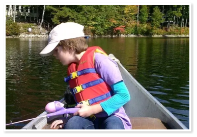 A boy canoeing and fishing on Duncan Lake