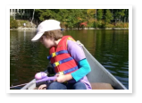 A boy canoeing and fishing on Duncan Lake